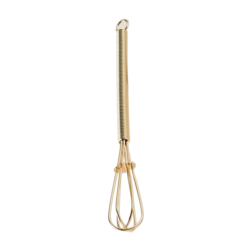 A gold-colored metal whisk with a long, tightly coiled handle and thin wire loops at the bottom, shown against a plain white background.
