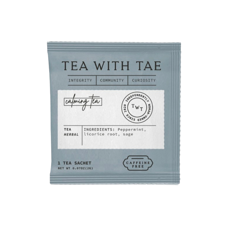 A single tea sachet package for 'Tea With Tae' herbal tea, featuring a muted slate blue-gray color with a white label in the center, set against a plain white background.