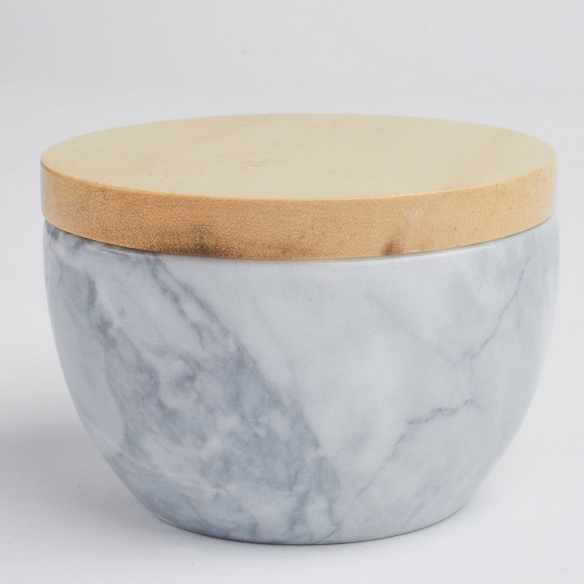 A round marble storage jar with a light natural wood lid, set against a plain light gray background.