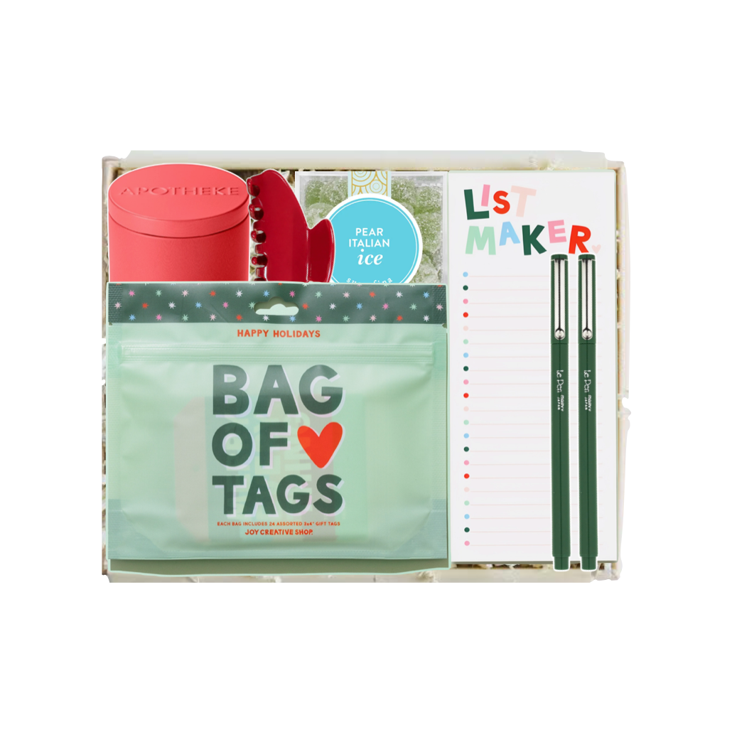 A curated gift box set containing a mint green 'Bag of Tags' pouch, a red cylindrical container, a red spiral notebook, a blue circular sticker, and a white 'List Maker' notepad with green pens, all arranged inside a clear plastic gift box on a white background.