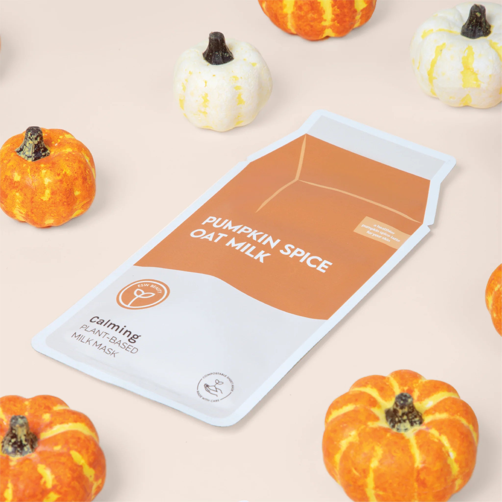 Pumpkin Spice Oat Milk Calming Plant-Based Milk Mask surrounded by mini pumpkins.