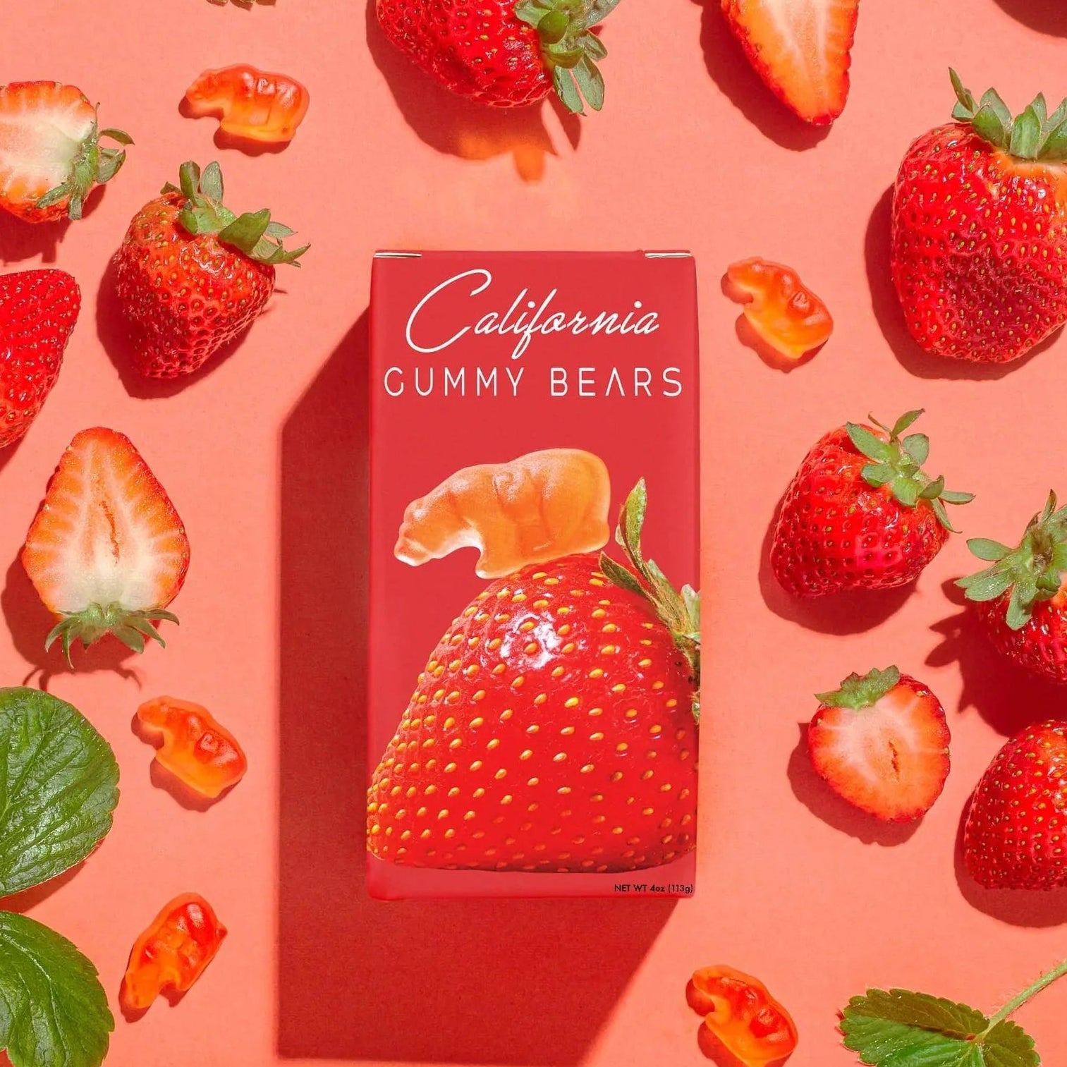 Box of California Gummy Bears surrounded by strawberries on a pink background