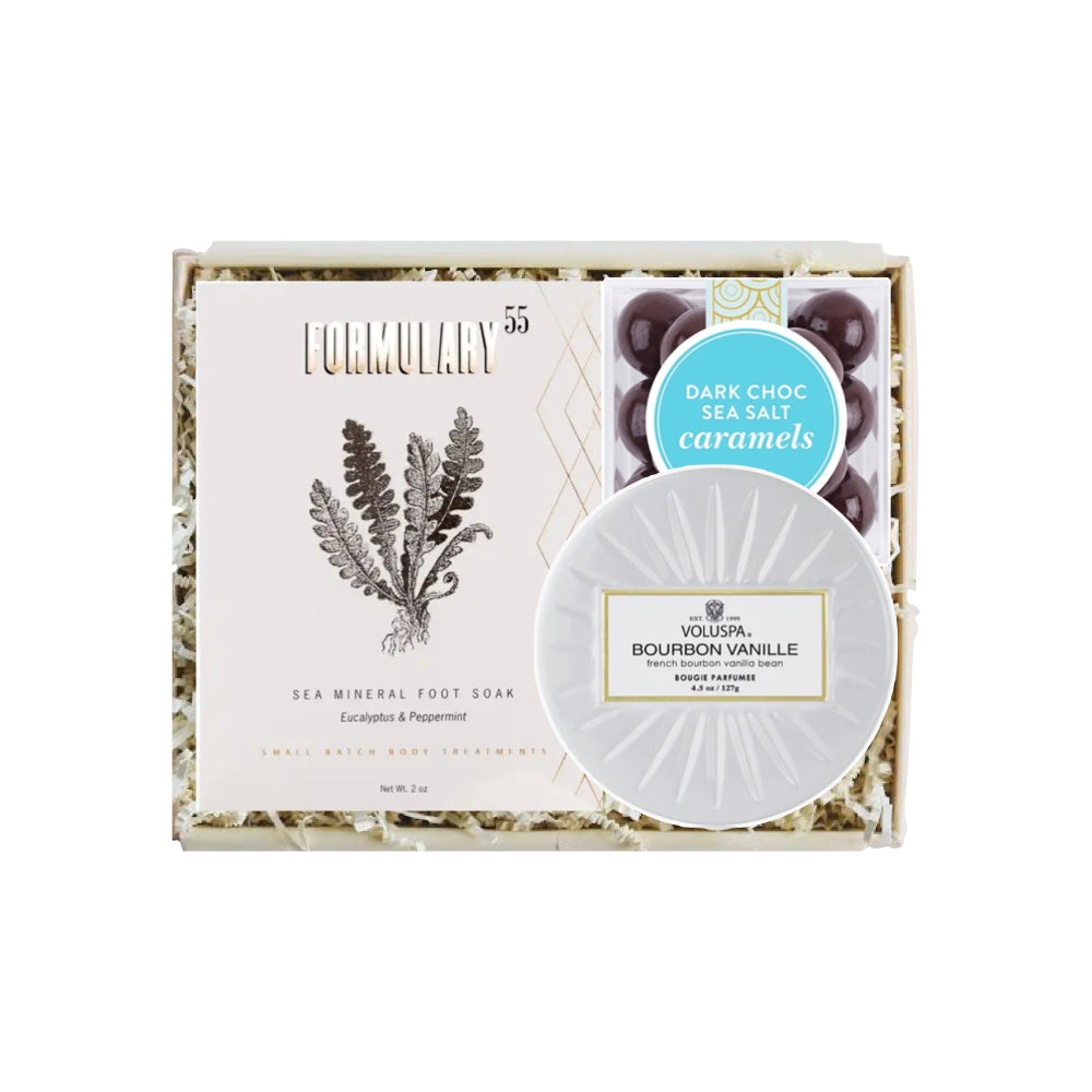 Box of Formulary 55 sea mineral foot soap with a small container of bourbon vanilla caramels on a white background