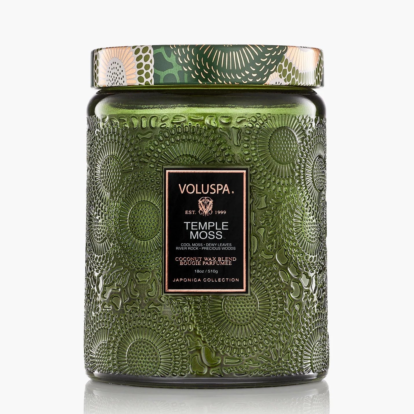 Green embossed candle jar with Voluspa label on a white background