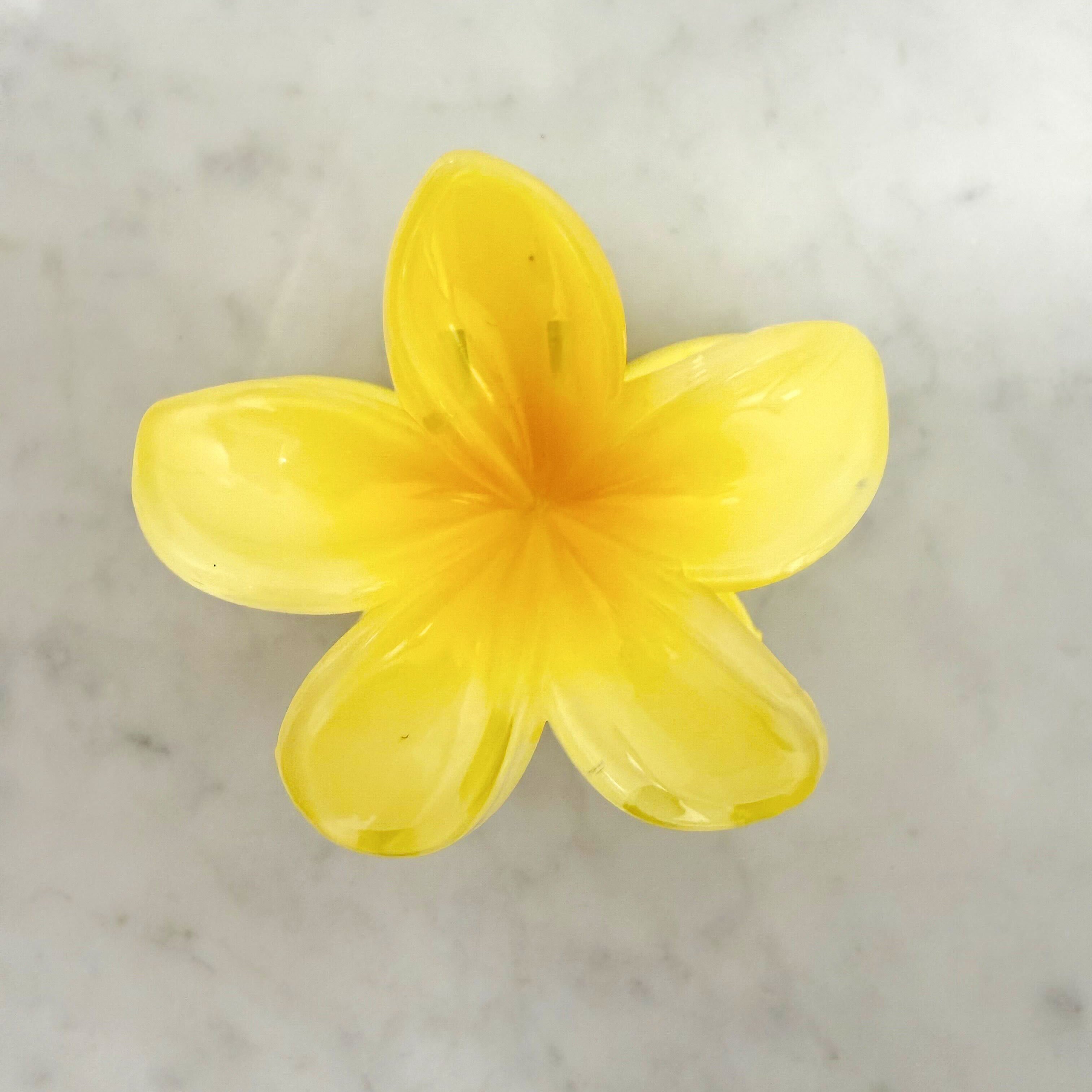Yellow flower-shaped object on a marble surface