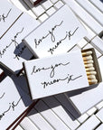 Matchboxes with 'love you mean it' text on a tiled surface