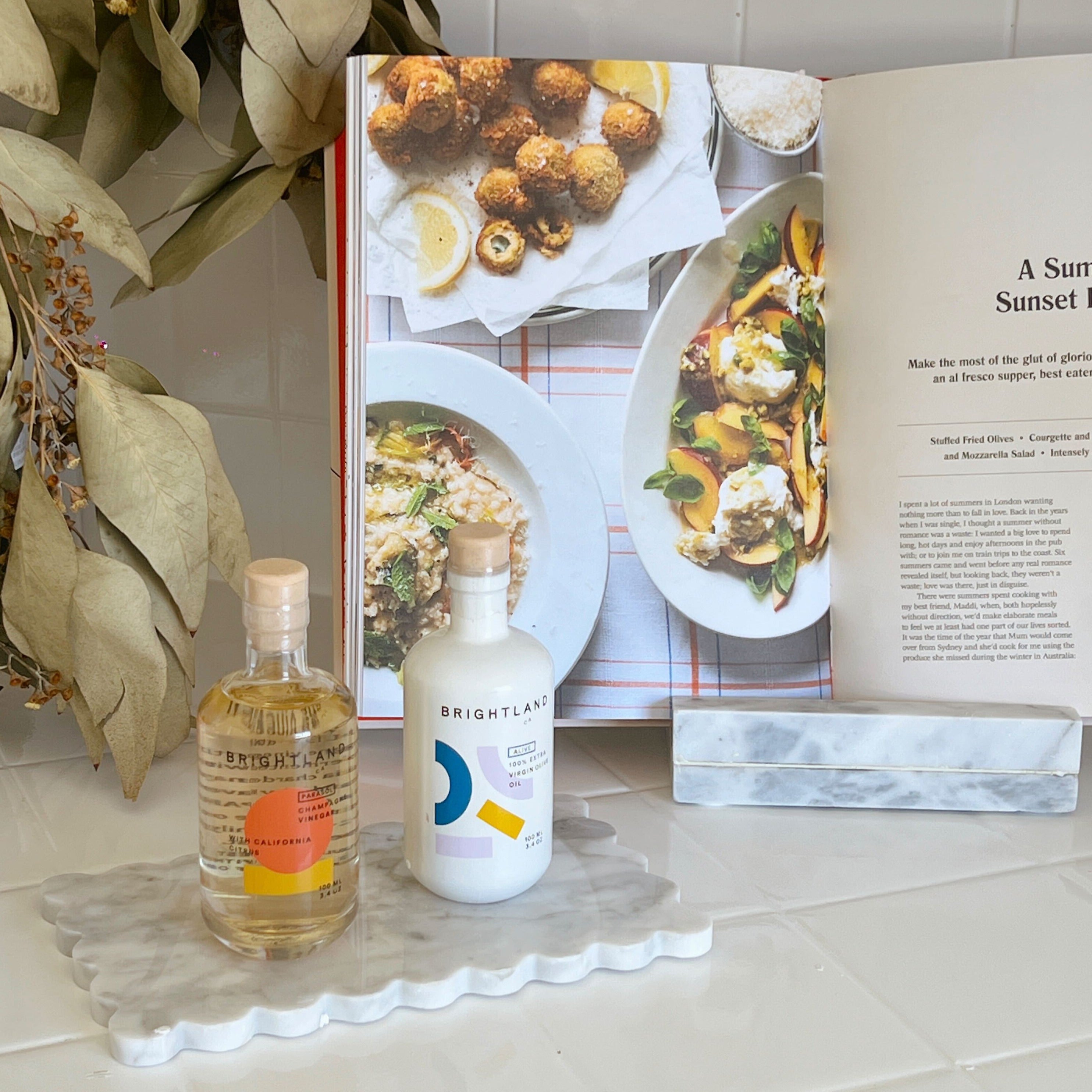 Oil and vinegar on White Scallop Marble Tray with cookbook in the background,