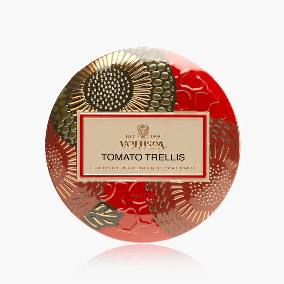 A round decorative tin of Whispa Tomato Trellis coconut wax body perfume, featuring a vibrant red background with gold and olive green botanical patterns and a central cream-colored label.