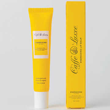 Yellow lip balm tube and packaging on a light gray background