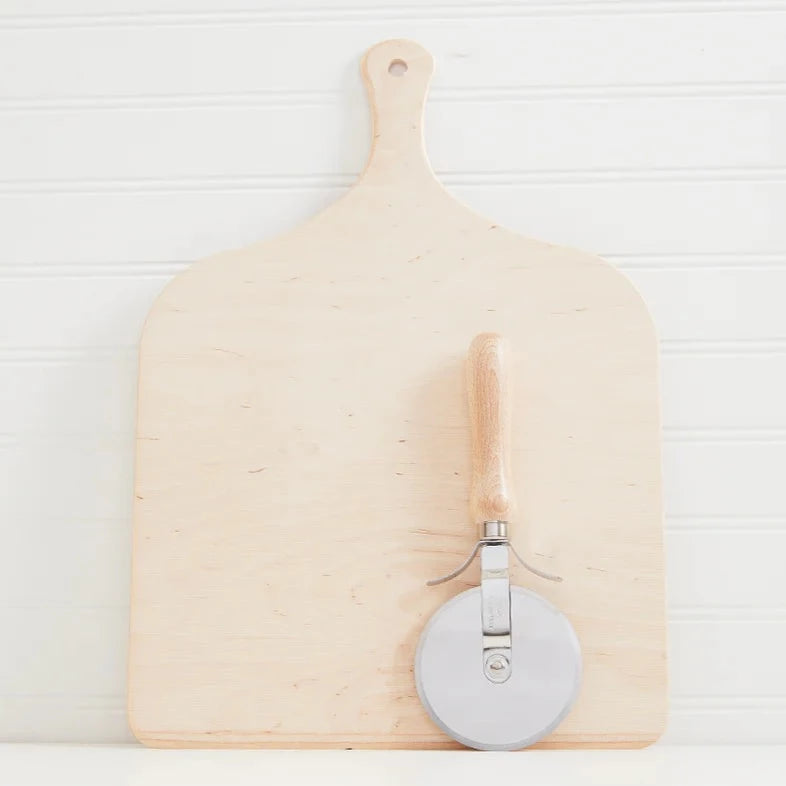 Verve Pizza Cutter leaning against wood cutting board