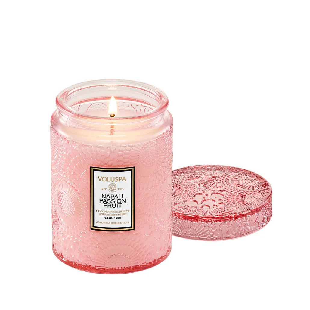 Pink candle with decorative lid on a white background