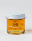 Jar of honey with a white lid on a light gray background