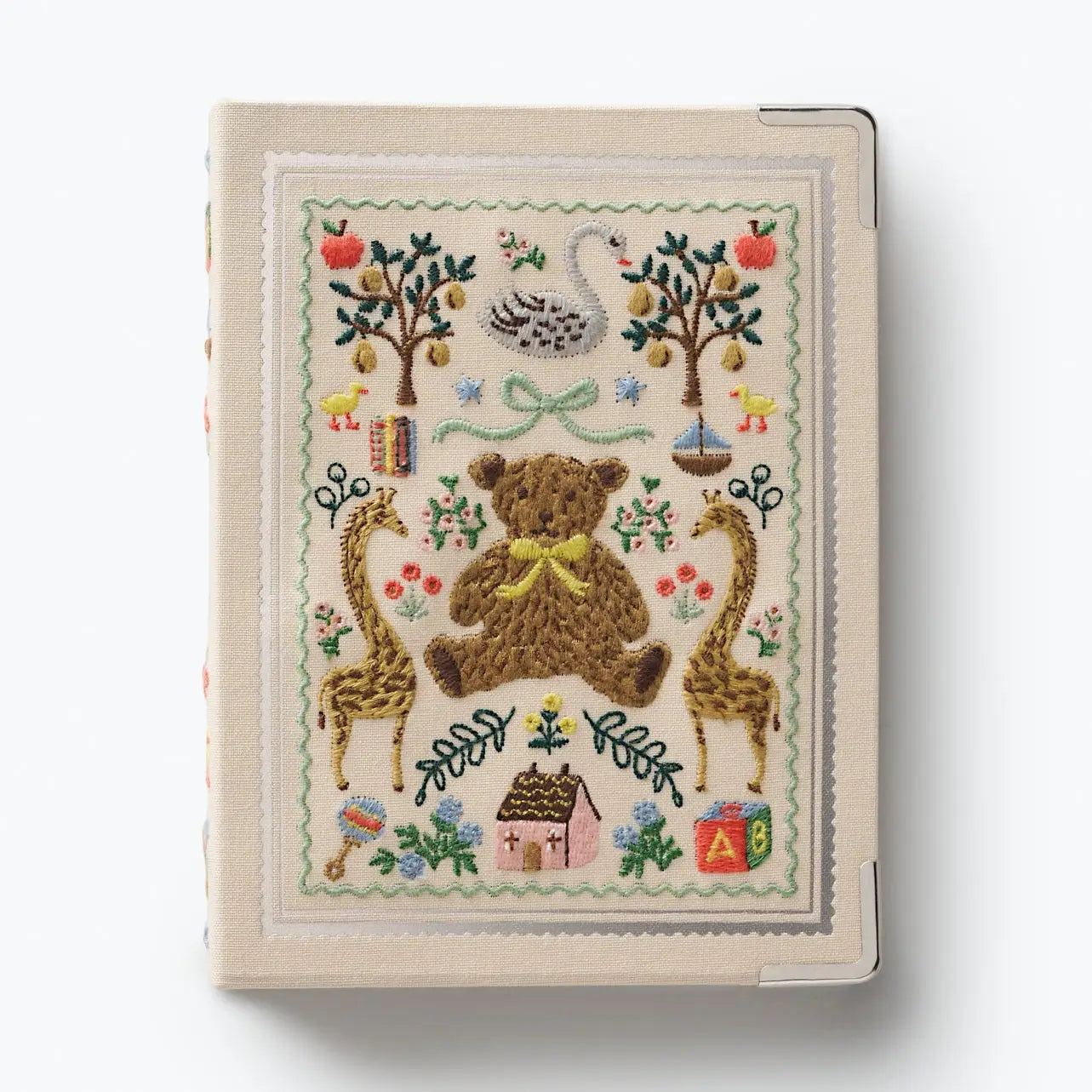 Embroidered notebook cover with teddy bear, giraffes, and nature-themed designs on a white background.