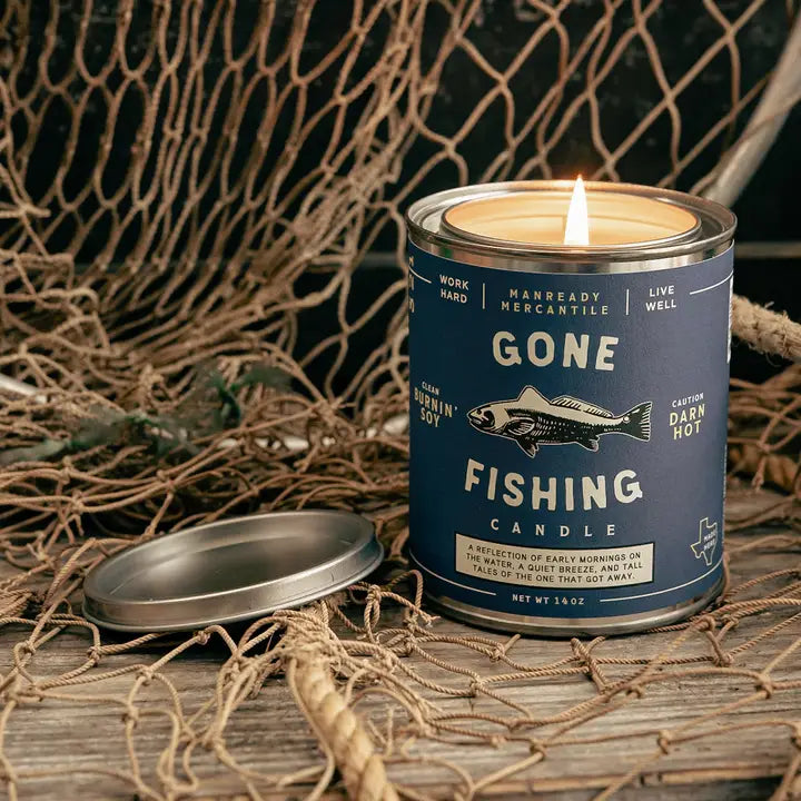 Gone Fishing candle in a blue can with a fish illustration on a fishing net background