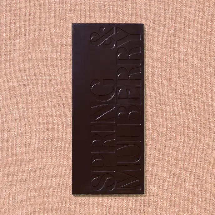 Dark chocolate bar with 'Spring & Mulberry' branding on a beige background