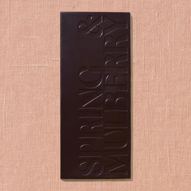 Dark chocolate bar with 'Spring &amp; Mulberry' branding on a beige background