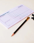 Scorecard with a pencil and checkers on a light surface