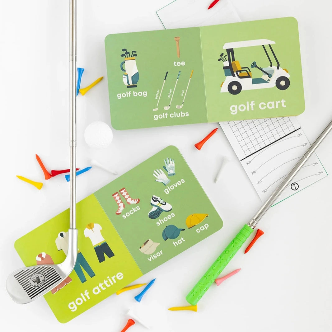 open golf baby books surrounded by golf clubs, tees, and balls