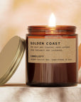 Candle with a label reading 'Tobacco + Rum' on a soft, warm background