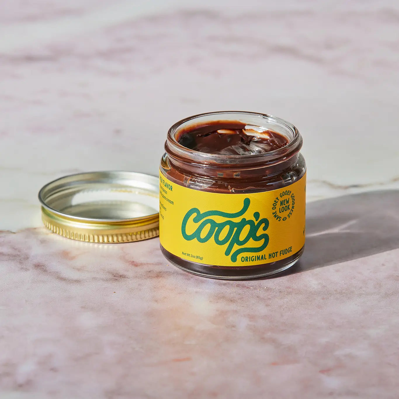 Jar of Coop's Original Hot Fudge on a marble surface