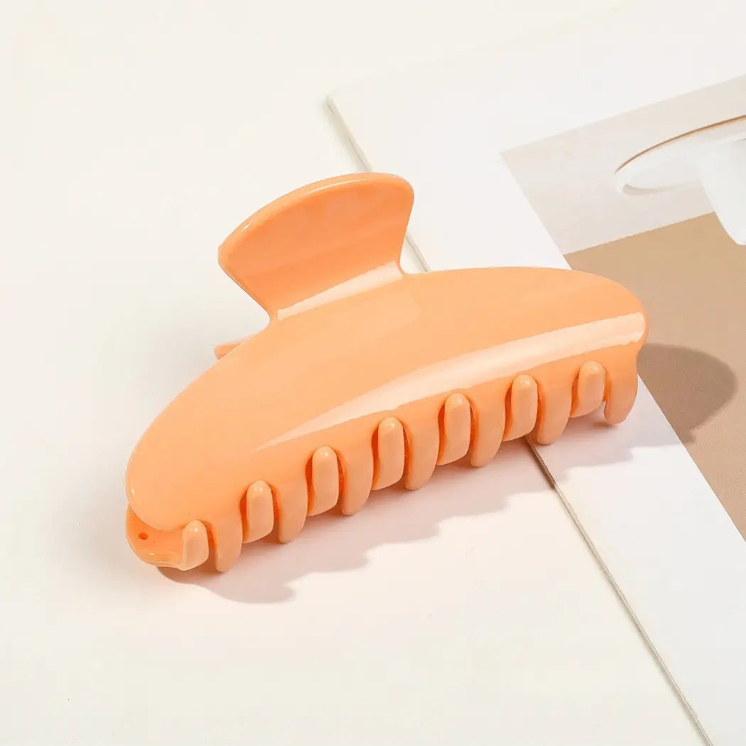 Orange hair claw clip on a light surface