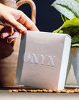 hand grabbing onyx monarch coffee box