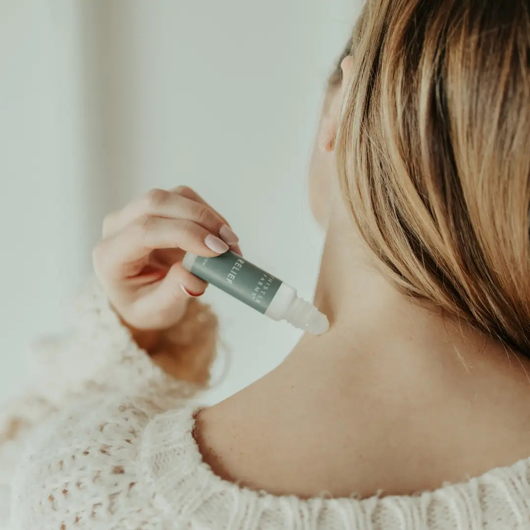Person applying a skincare product to their neck with a dropper.