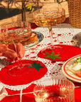 Two glasses of champagne on red coasters with a table setting including a salad.