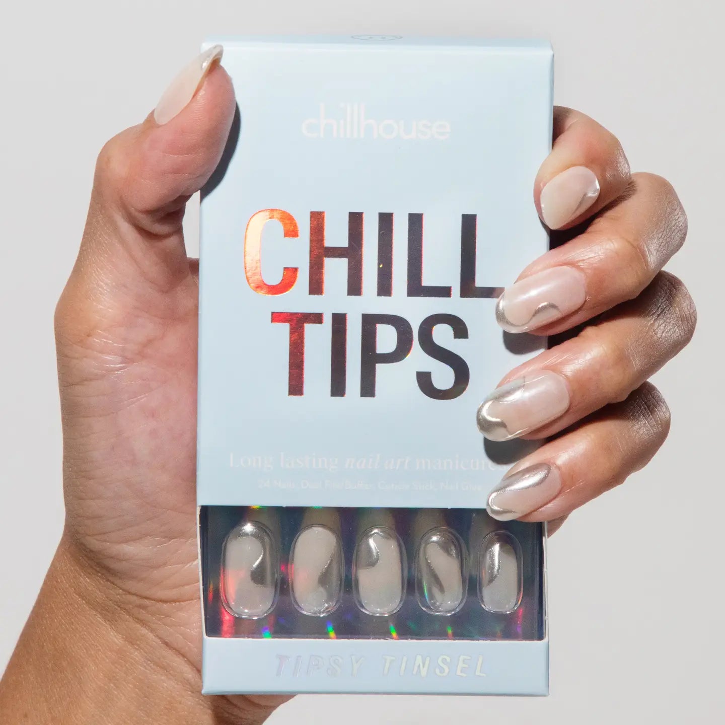 Hand holding a box of 'Chill Tips' with false nails.