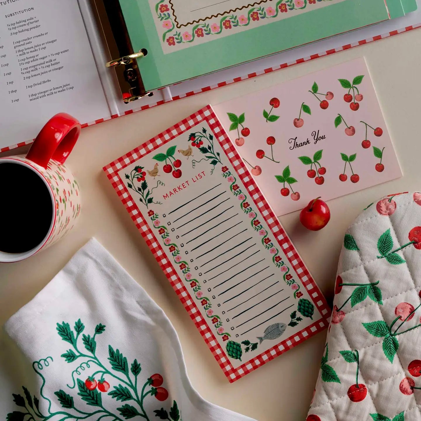 cherry notepad on a table with a cherry mug card towel and mit 