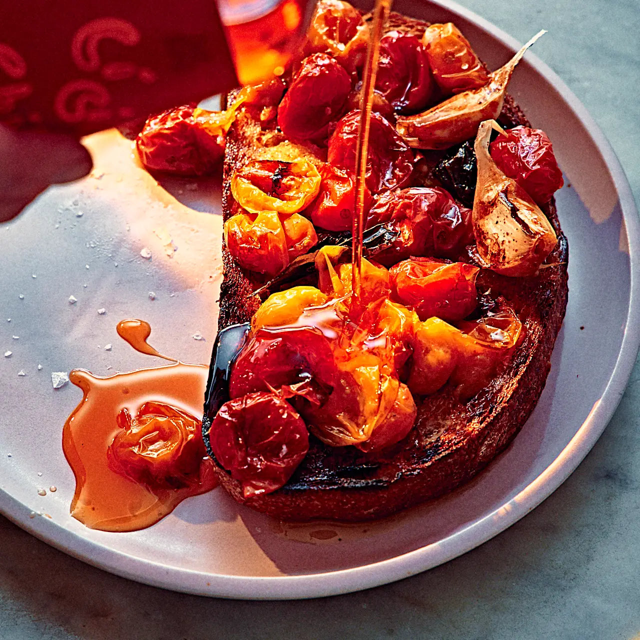 Close-up of a dish with roasted vegetables and a drizzle of sauce on a white plate.