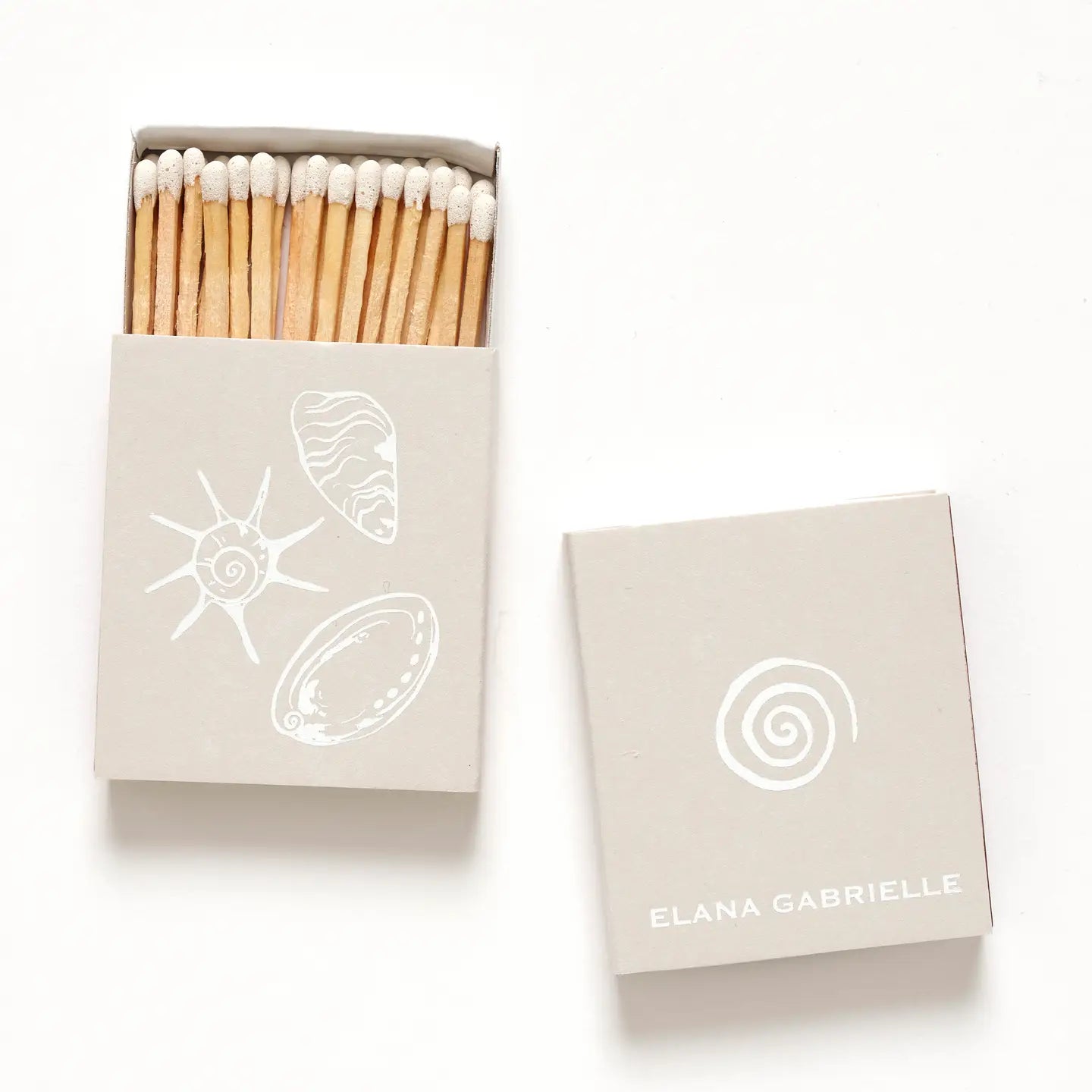 Matches in a beige box with white designs and 'Elena Gabrielle' branding on a white background