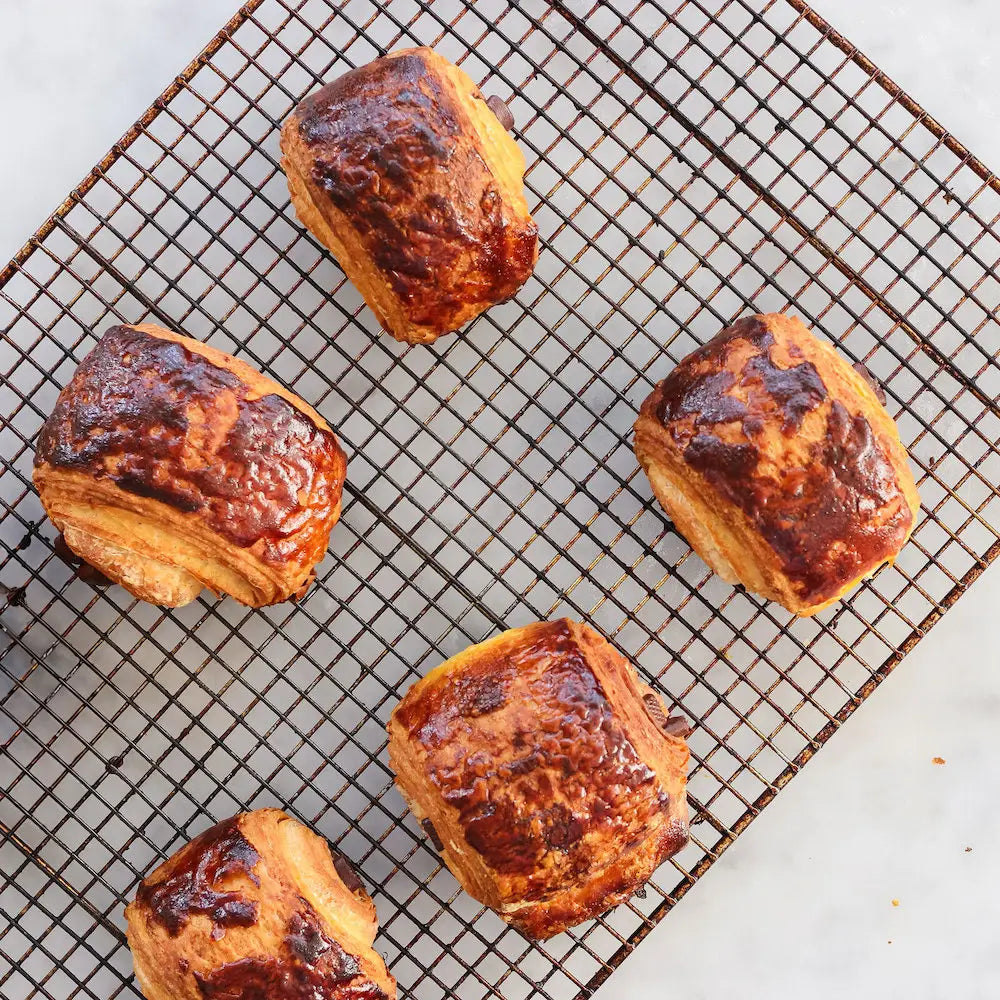 Croissants on a cooling rack with a white background