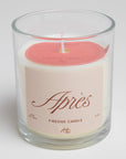 glass candle that has a light red label that says "APRÉS" on it