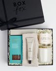 BOXFOX Matte Black gift box packed with oatmilk hot chocolate, stone luxe cozy socks, salt and stone santal hand lotion, apres candle and grey mug