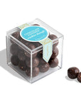 Clear cube container with chocolate cookie dough balls and a blue label on a white background