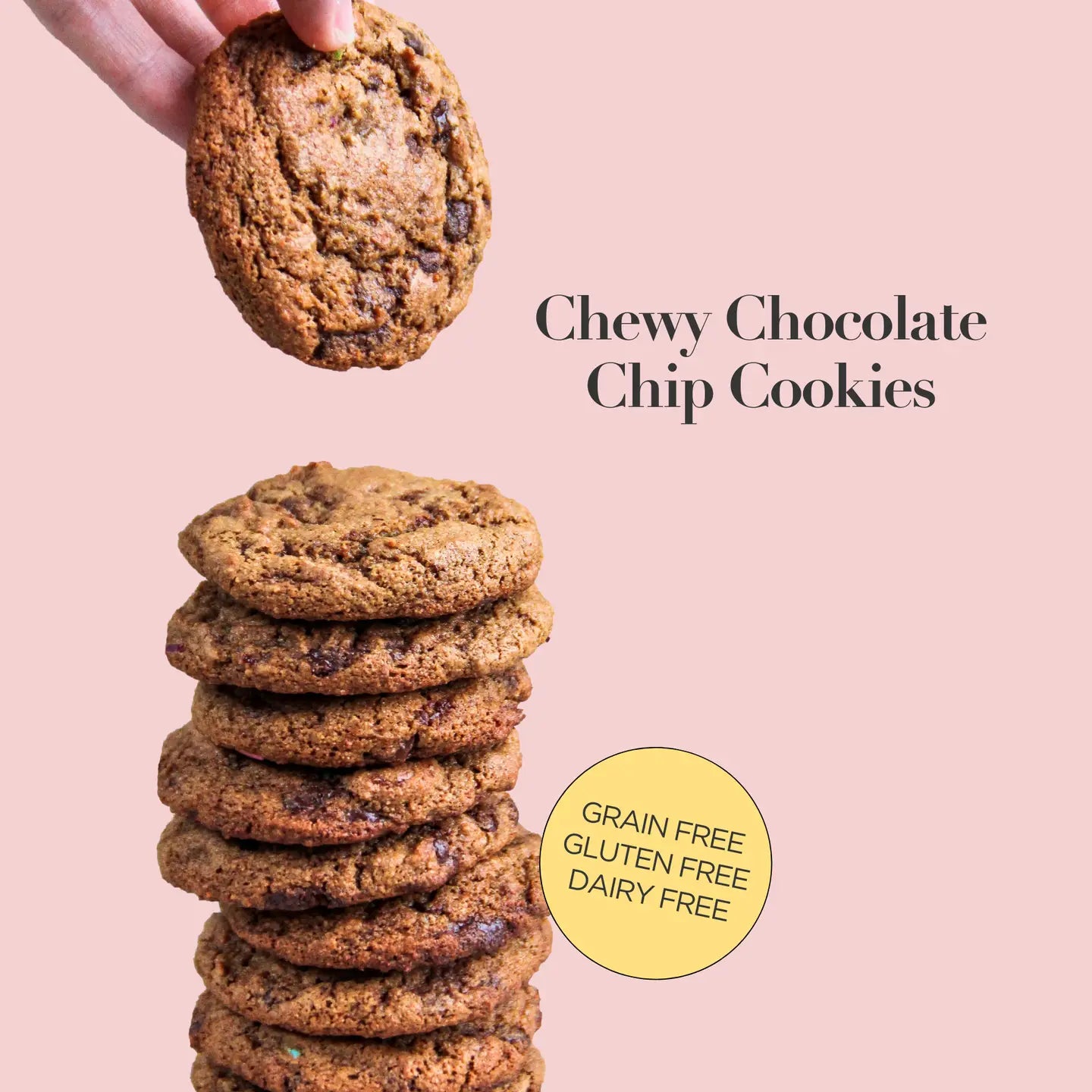 Stack of chewy chocolate chip cookies with a hand holding one above, on a pink background.