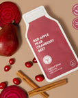red sheet mask surrounded by apples, beets, cranberries, and cinnamon sticks