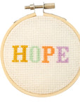 embroidery hoop with pastel colored letters spelling HOPE in the center