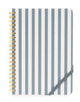 Notebook with blue and white striped cover and gold spiral binding on a white background