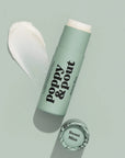Green lip balm with 'Poppy & Pout' branding on a light gray background