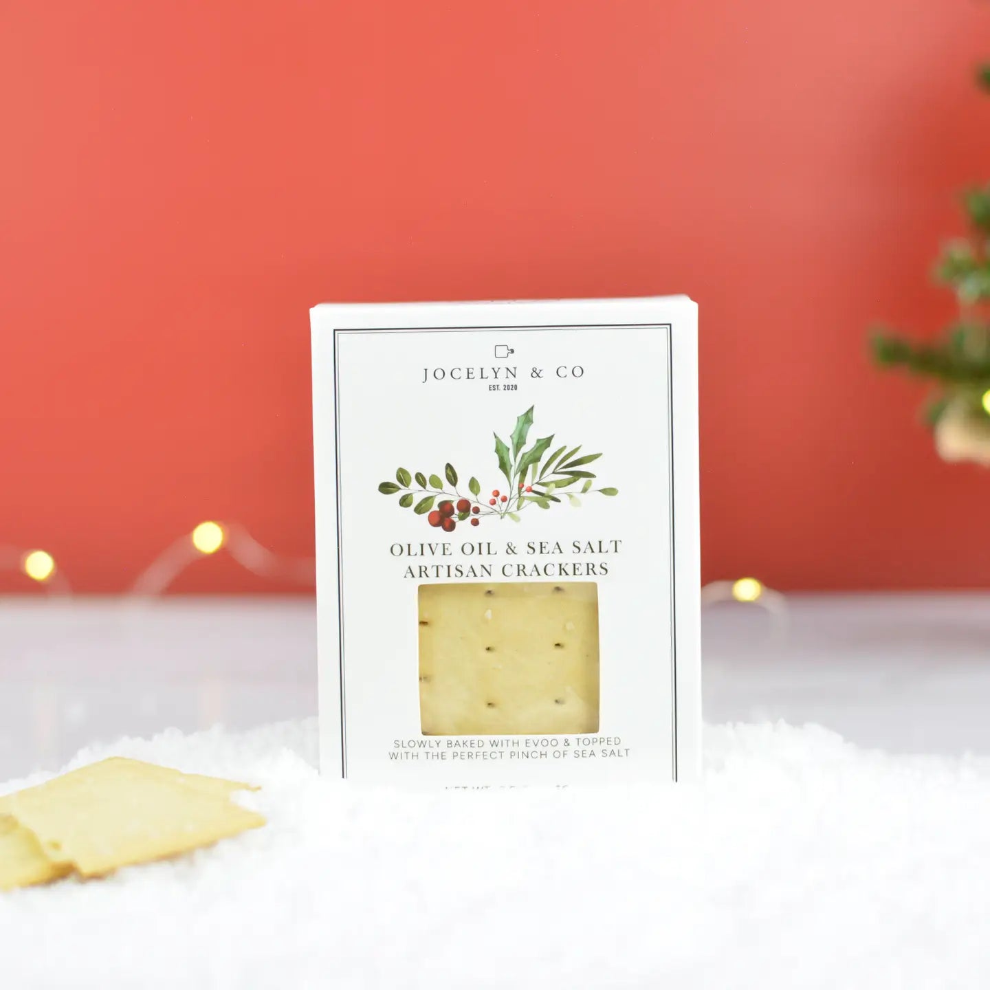 white cracker box that says olive oil and sea salt artisan crackers against a red background 
