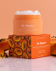 orange body butter next to papayas