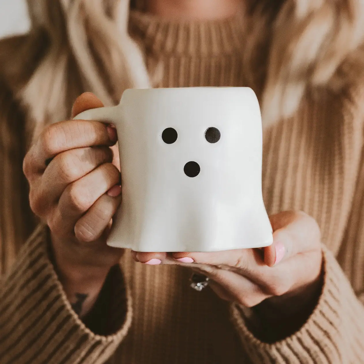 girl holding a ghost coffee mug