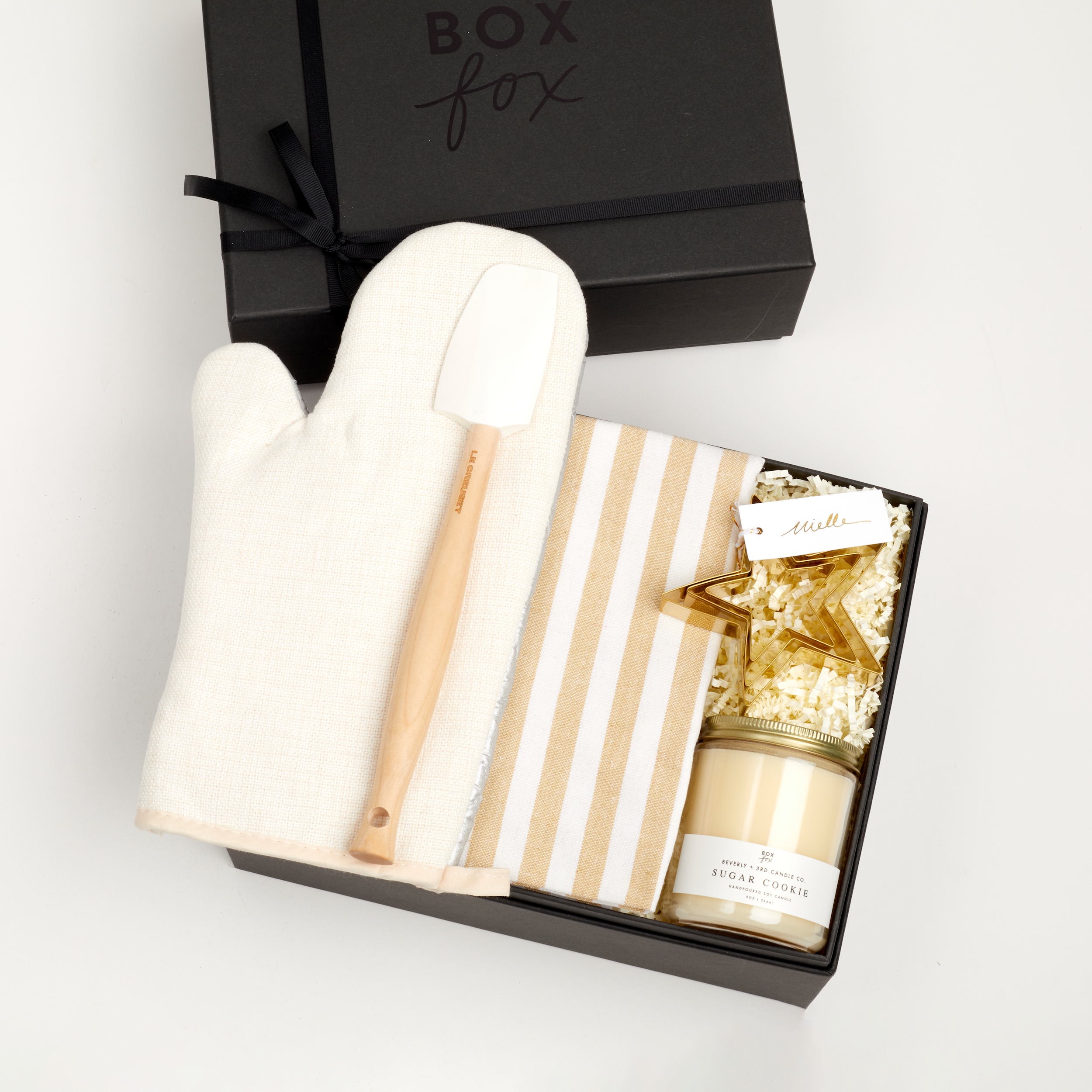 The BAKING box in black, which includes an oven mitt, spatula, striped dish towel, cookie cutters and a sugar cookie candle.