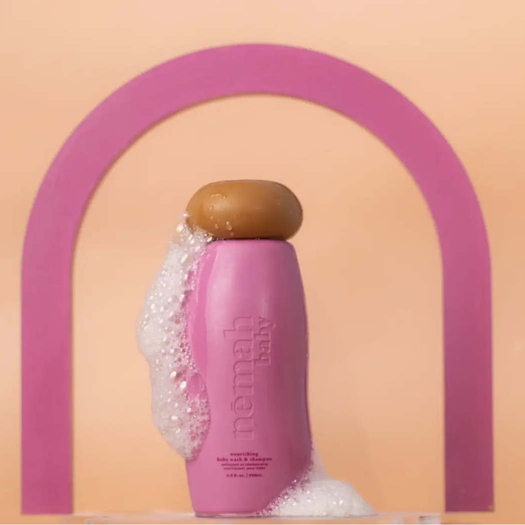 Pink bottle with wooden cap on a peach background with a pink arch