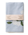 blue tea towel with white hydrangea embroidered on it