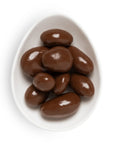 Chocolate-covered almonds on a white plate with a white background