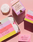 Birthday-themed bath and shower products on a pink background