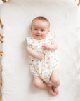 baby wearing the whale tales romper in a crib